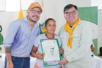 Mujer recibiendo el título de su predio.