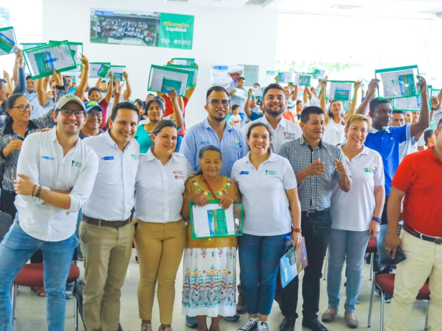 Grupo de personas mostrando sus títulos, durante el evento de entrega de títulos en Puerto Asís, Putumayo.