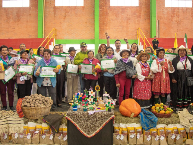 Campesinos recibiendo los títulos de sus tierras.
