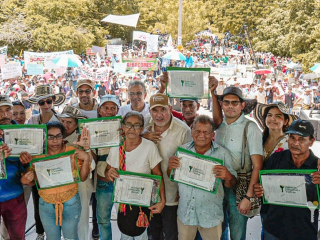 Campesinos recibiendo los títulos de sus tierras.