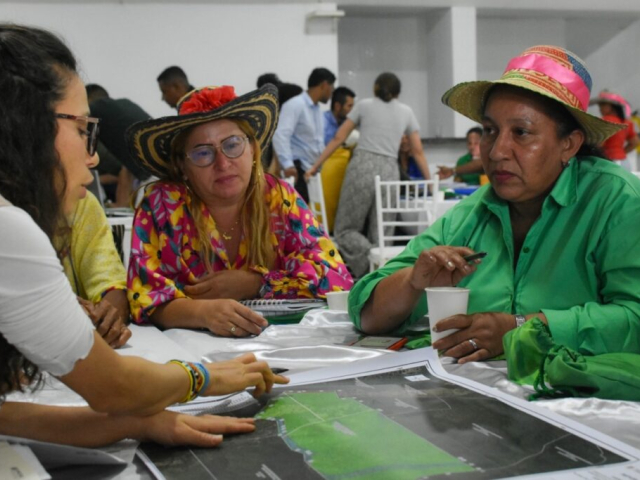 Tres mujeres conversando en una mesa de diálogo.