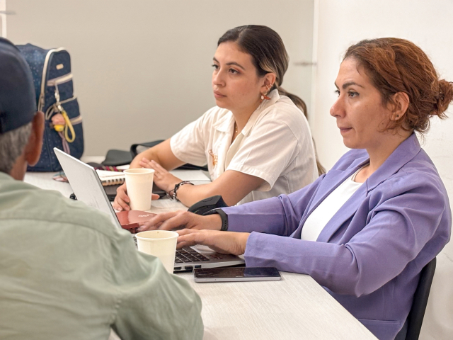una-mujer-y-dos-hombres-sentados-en-una-mesa-con-computadoras-portatil