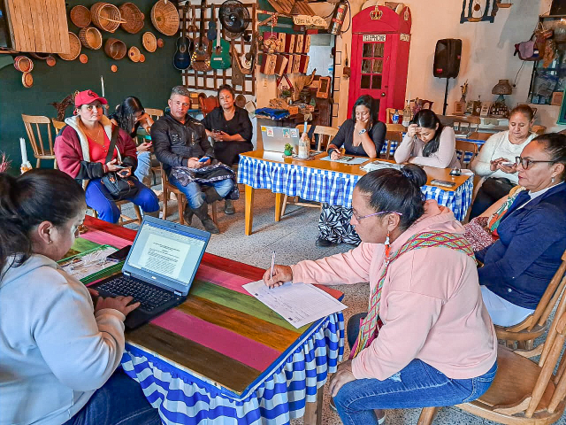 un-grupo-de-personas-sentadas-alrededor-de-una-mesa-con-funcionarios-ant