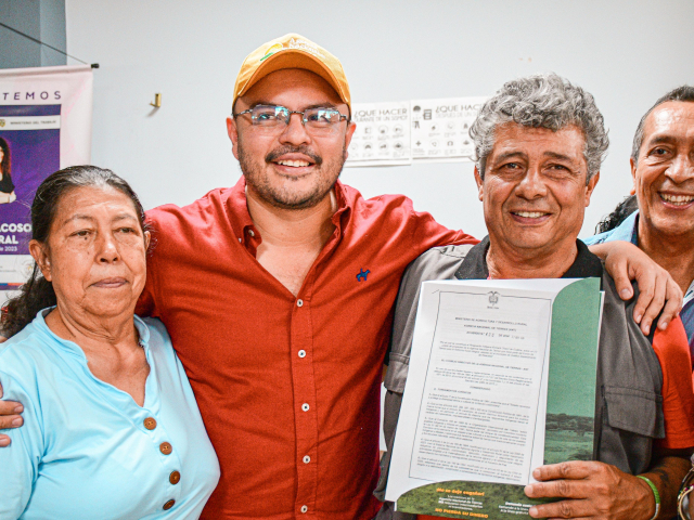 director-ant-junto-a-un-hombre-que-tiene-un-certificado-con-un-grupo-de-personas