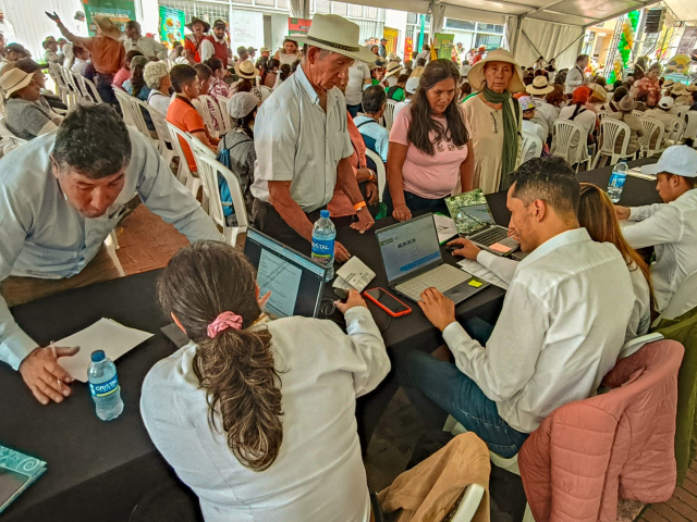 gente-sentada-en-mesas-con-computadoras-porttiles-y-papeles