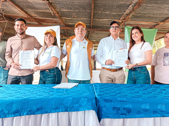 un-grupo-de-personas-de-pie-alrededor-de-una-mesa-con-un-mantel-azul