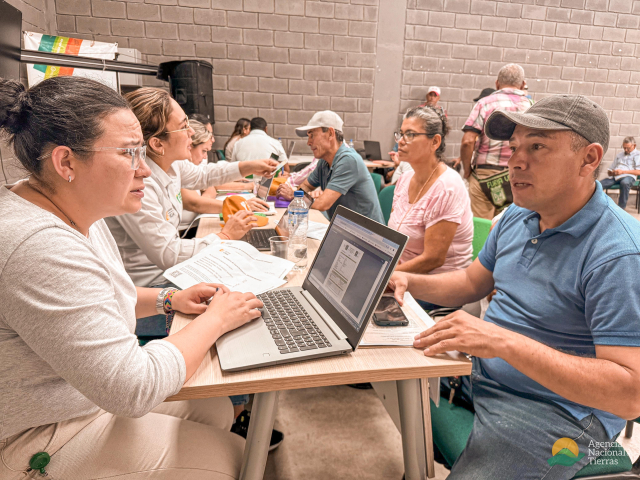 un-grupo-de-personas-sentadas-en-una-mesa-con-computadoras-portatiles