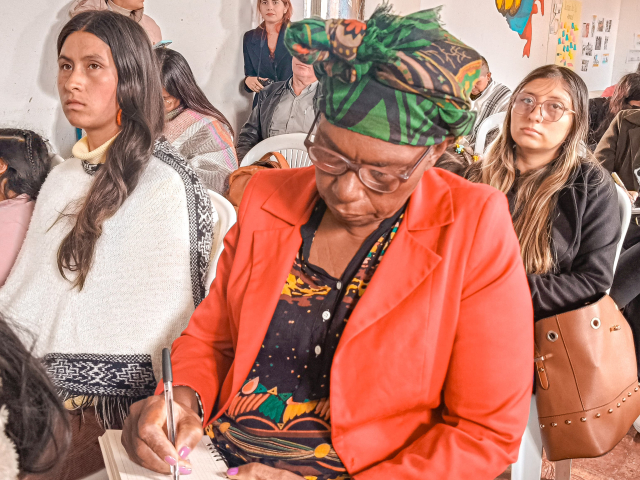 una-mujer-sentada-en-una-silla-con-un-grupo-de-personas