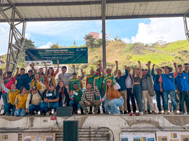 un-grupo-de-personas-paradas-en-un-escenario-con-las-manos-en-alto