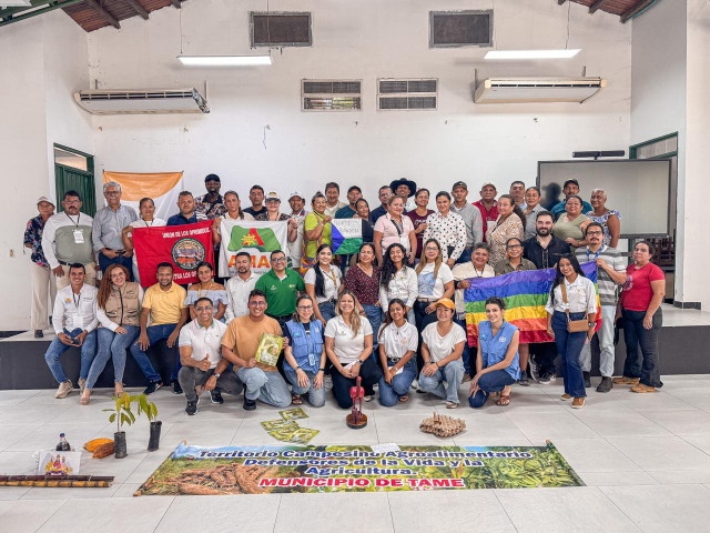 un-grupo-de-personas-posando-para-una-foto-frente-a-una-pancarta