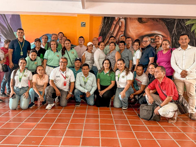un-grupo-de-personas-posando-para-una-foto-frente-a-un-mural