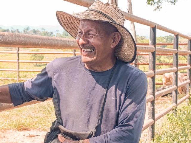 un-hombre-con-sombrero-parado-junto-a-una-valla