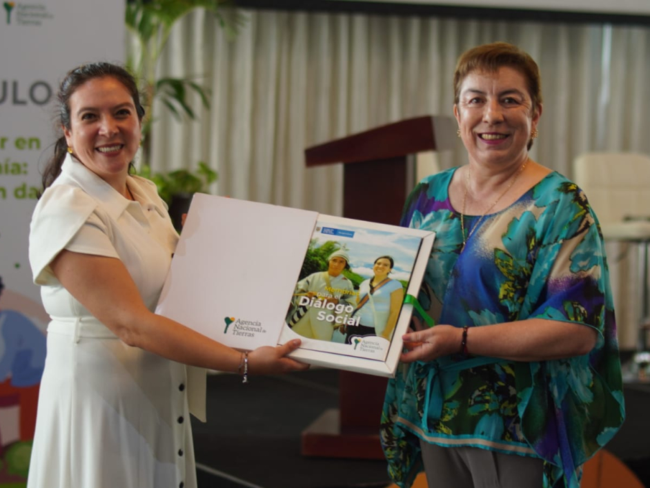 Ex directora de la ANT junto a otra funcionaria, mostrando el libro Memorias para el Diálogo Social