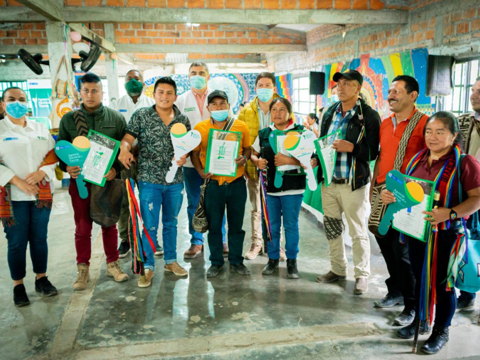 Funcionarios de la ANt junto a personas de diferentes resguardos indigenas mostrando los titulos de ampliación y constitución