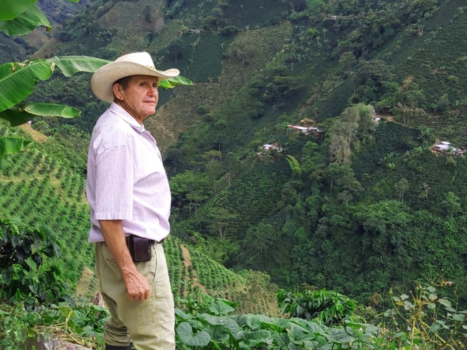 Señor campesino en las montañas donde hay algunas siembras.