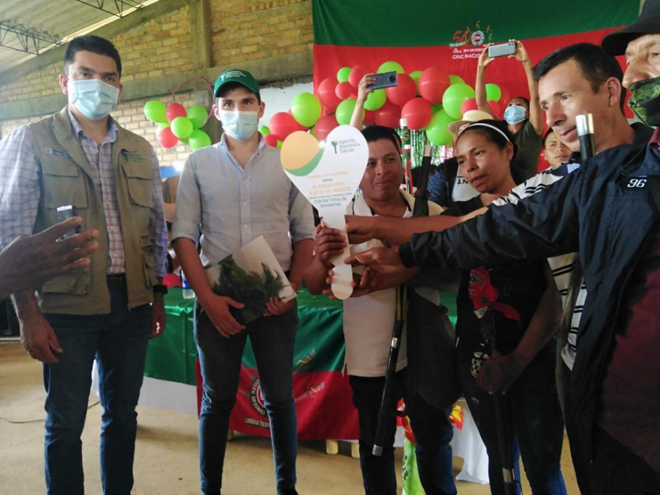 Siete integrantes de tres resguardos indígenas ubicados en el departamento del Cauca, reciben de parte de dos hombres funcionarios de la ANT la llave como símbolo del título de propiedad de los predios de los resguardos indígenas. 
