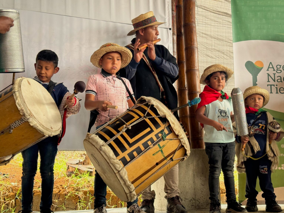 Indígenas tocando instrumentos típicos en entrega de tierras ANT