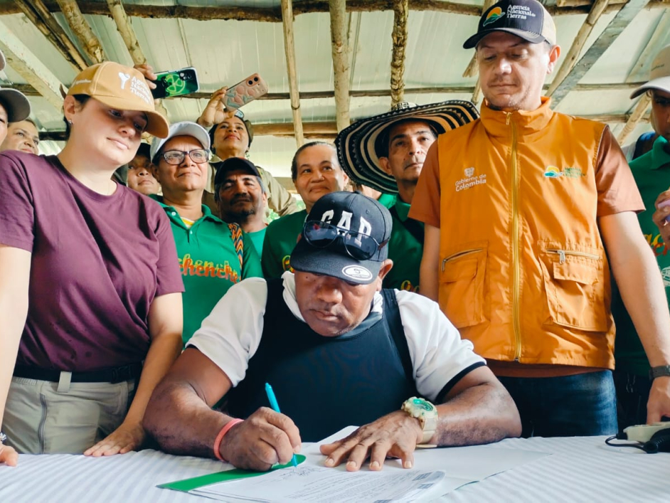 un-grupo-de-personas-parados-alrededor-de-una-mesa-firmando-papeles