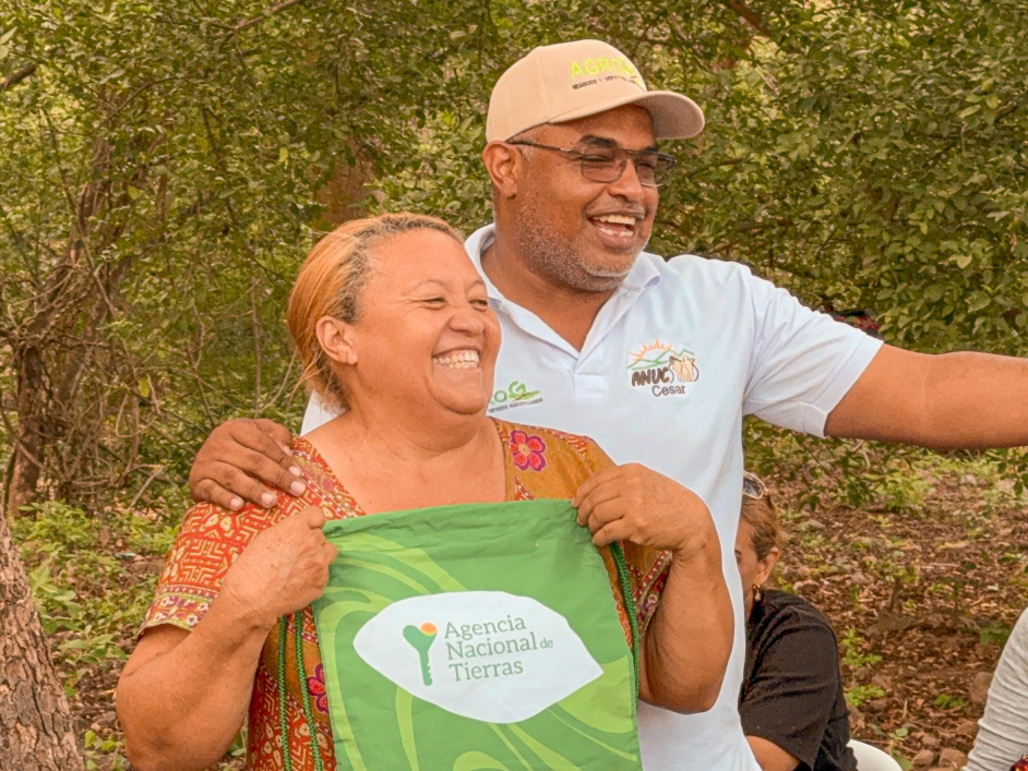 un-hombre-y-una-mujer-sosteniendo-una-bolsa-verde-frente-a-los-arboles
