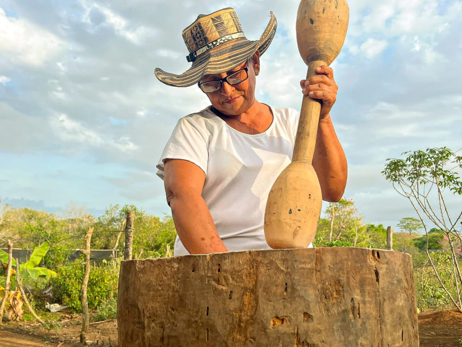 una-mujer-con-un-sombrero-sostiene-un-palo-de-madera