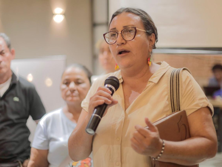 una-mujer-con-gafas-hablando-por-un-microfono